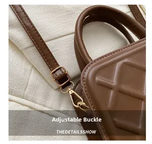 Détail du sac en cuir matelassé marron avec boucle dorée et bandoulière réglable