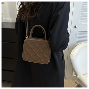 Vue détaillée d'un sac bandoulière marron matelassé avec poignée en simili cuir