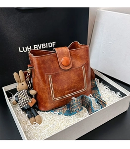Sac seau rétro marron avec poches à rivets et bandoulière tissée colorée en gros plan