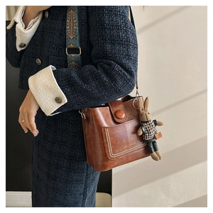 Détail du sac seau marron rétro avec bandoulière ethnique et breloque lapin