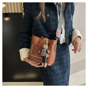 Détail du sac seau marron rétro avec bandoulière tissée et porte-clés lapin mignon