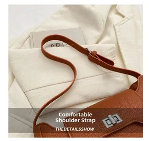 Detail of adjustable brown pebbled leather shoulder strap with silver buckle hardware