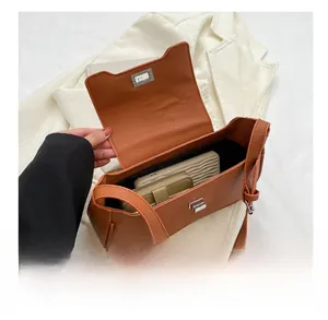 Internal capacity view of brown orange leather crossbody bag with silver twist lock buckle