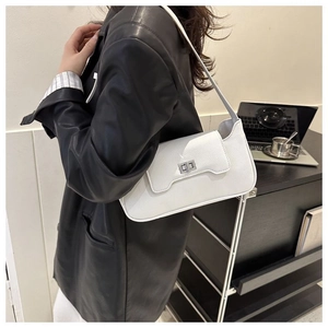 Side view of white lychee leather shoulder bag with a silver metal clasp closure