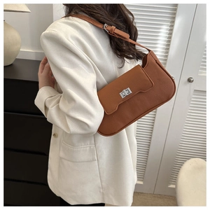 Brown lychee texture shoulder bag with silver turn-lock clasp shown on a model