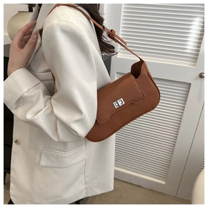 Detail of a brown lychee pattern leather shoulder bag with a silver metal buckle lock