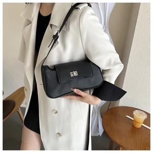 Close-up of black litchi texture leather shoulder bag with silver square metal lock