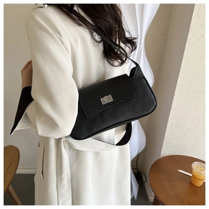 Detailed view of the litchi textured leather shoulder bag with a silver turn-lock clasp