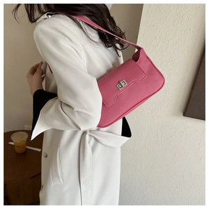 Detail of hot pink litchi leather shoulder bag with a silver rectangular metal clasp