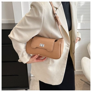 Detail of camel leather shoulder bag with silver metallic buckle and pebble texture