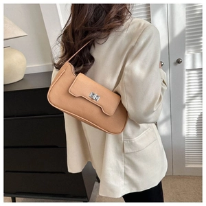 Detail of caramel lychee textured leather baguette bag with silver metal square buckle