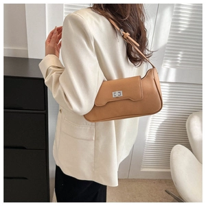 Detail of tan pebble leather shoulder bag featuring a silver rectangular twist lock