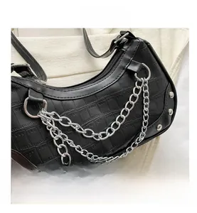Detail of black crocodile pattern bag featuring triple silver metal chains and rivets