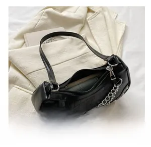 Close-up showing the spacious interior and crocodile embossed texture of the black baguette bag