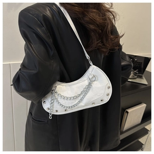 Detail of white half-moon bag with croc texture, silver chains and rivets decoration