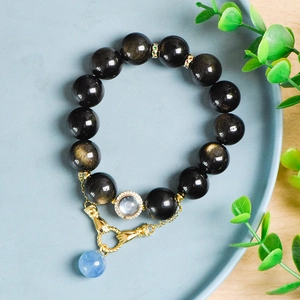 Goldobsidian 14mm Perlenarmband mit Aquamarin-Akzent auf einer Keramikplatte