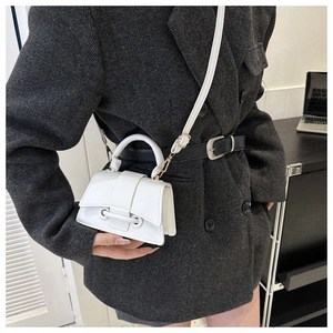 Detailansicht der weißen Mini-Tasche mit Litschimuster, geschwungenem Boden und Griff