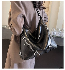 Close-up of black Hobo tote bag featuring silver zippers and adjustable buckles for daily use