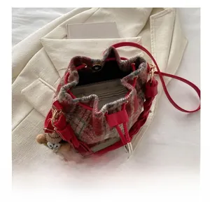 Top view of red plaid wool bucket bag showing interior pocket and teddy bear charm