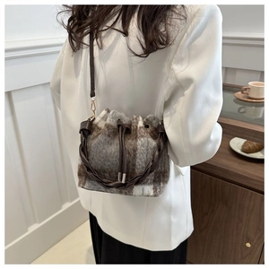 Detail of wool plaid bucket bag with drawstring closure and woven handle in daily setting