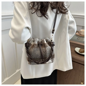Detail of wool plaid bucket bag with woven handle and drawstring closure for women