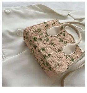 Detail showing the floral lace texture and sturdy rectangular base of this mini handbag