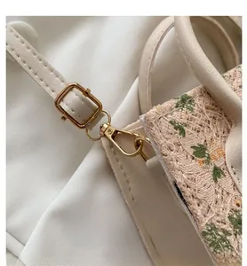 Close-up of golden hardware hooks and leather strap on woven lace mini handbag