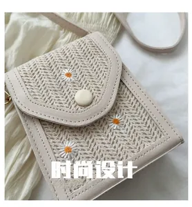 Close-up of woven straw texture with white daisy embroidery and cream leather trim