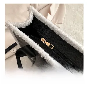 Détail du zip métallique sur sac en cuir noir avec bordure en fausse fourrure