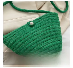 Gros plan sur le tissage de corde verte et le bouton en perle blanche du sac