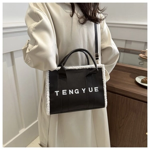 Détail du sac cabas en cuir noir avec bordure en peau lainée blanche et bandoulière amovible