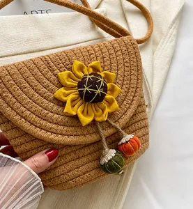 Detailed view of woven straw bucket bag with sunflower decor and colorful charms