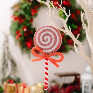 Sucette de Noël spirale rouge et blanc avec nœud pailleté sur une branche