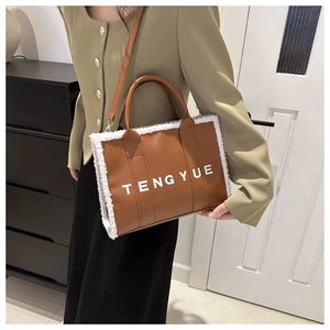 Détail du cabas en cuir PU marron avec bordure en fausse fourrure blanche et texte TENG YUE