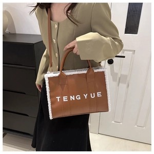 Sac cabas en cuir marron avec bordure en fourrure blanche porté en bandoulière