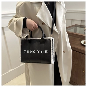 Détail d'un sac en cuir noir avec bordure en fausse fourrure blanche et lettrage TENGYUE