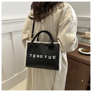 Détail du cabas en cuir noir avec bordure en polaire blanche et logo TENG YUE sur le devant