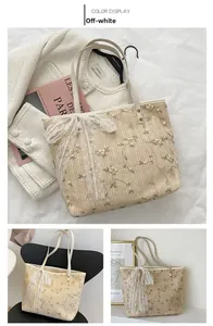 Detail of straw woven tote bag featuring floral embroidery and a white lace bow accent