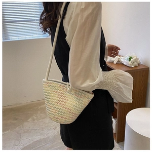 Détail du sac seau tissé avec rayures arc-en-ciel et fermeture par bouton en perle