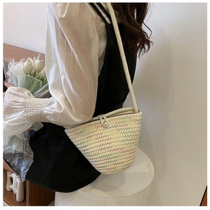 Détail d'un sac seau tissé avec motif à chevrons colorés et fermoir perle élégant