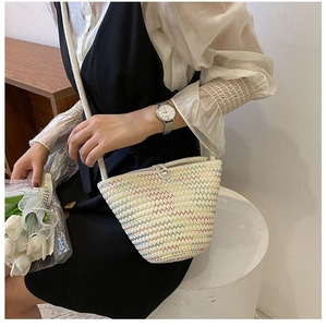 Détail du sac seau en paille tissée colorée avec motifs ondulés et fine bandoulière