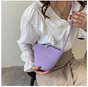 Détail du sac seau tissé violet avec fermoir perle et bandoulière tressée