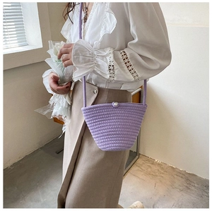 Détail du sac seau tissé lavande avec fermoir perle et fine bandoulière élégante