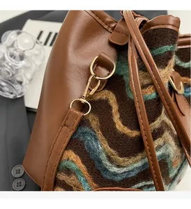 Close-up of bucket bag showing wavy knit fabric and premium brown leather details