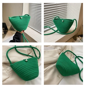 Détail du sac seau tissé en paille verte avec perle décorative et bandoulière chic
