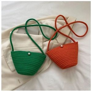 Détail de sacs seaux tissés à la main en vert et orange avec élégant fermoir perle