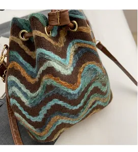 Detalle de bolso saco de punto bohemio con estampado de ondas y cordón de cuero