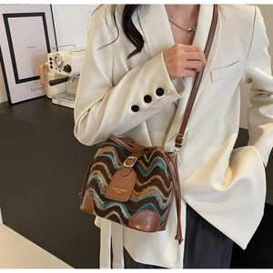 Detail der Boho-Beuteltasche mit gewebtem Wellenmuster und braunem Lederbesatz