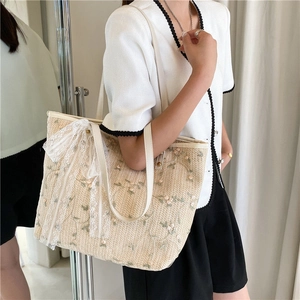 Chic woven straw tote bag with floral embroidery and white lace bow decoration