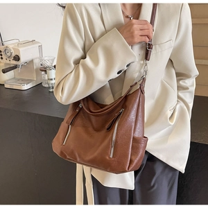 Détail du sac cabas marron en cuir avec zips fonctionnels et fine bandoulière